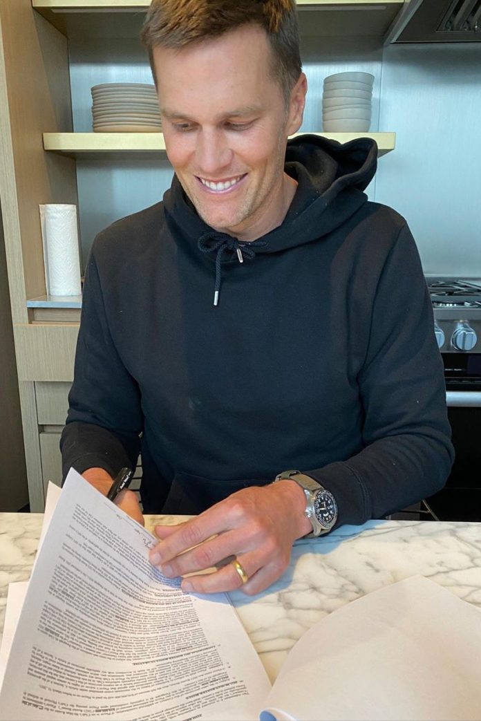 Tom Brady signing his new contract with the Tampa Bay Buccaneers