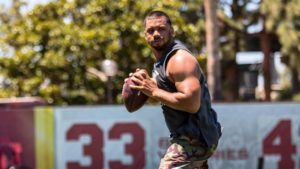 Russell Wilson showing off his arms after a workout